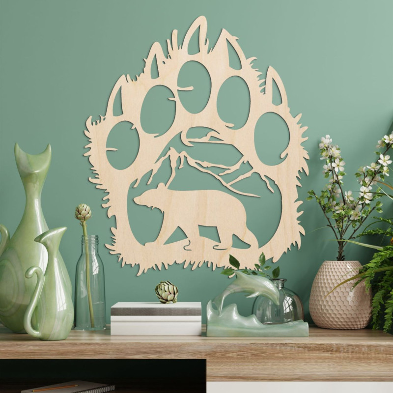 O siluetă contrastantă a unei cărări de urs, în interiorul căreia se poate observa un lanț muntos și figura unui urs care merge