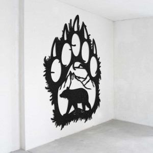 O vedere de aproape a unui motiv natural reprezentând un urs și munți în interiorul unei labe mari de lemn.