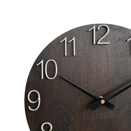 Ceas de perete din lemn cu cifre sculptate și ace metalice.