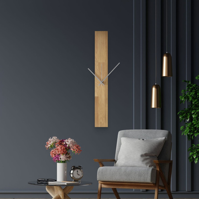 Ceas de perete modern, lipit pe un perete alb, cu ace negre simple.