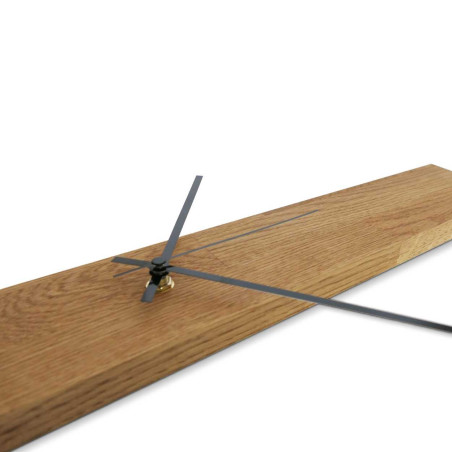 Ceas minimalist din lemn, în formă de panou îngust, cu ace argintii și negre.